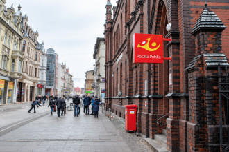 Budynek Poczty Polskiej przy ul. Królowej Jadwigi w Inowrocławiu z czerwoną skrzynką pocztową