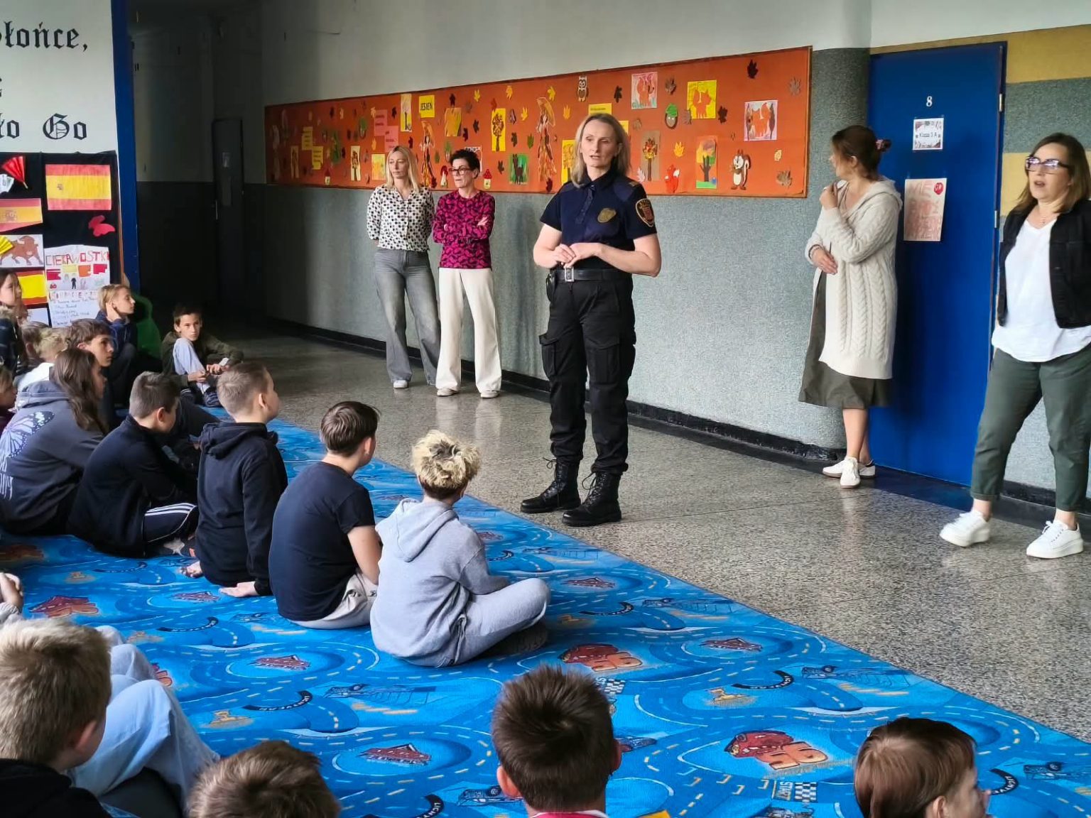 Strażniczka miejska rozmawia z uczniami podczas spotkania edukacyjnego w szkole w Inowrocławiu.