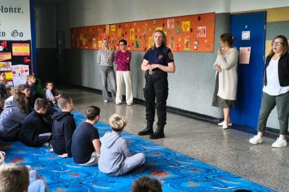 Strażniczka miejska rozmawia z uczniami podczas spotkania edukacyjnego w szkole w Inowrocławiu.
